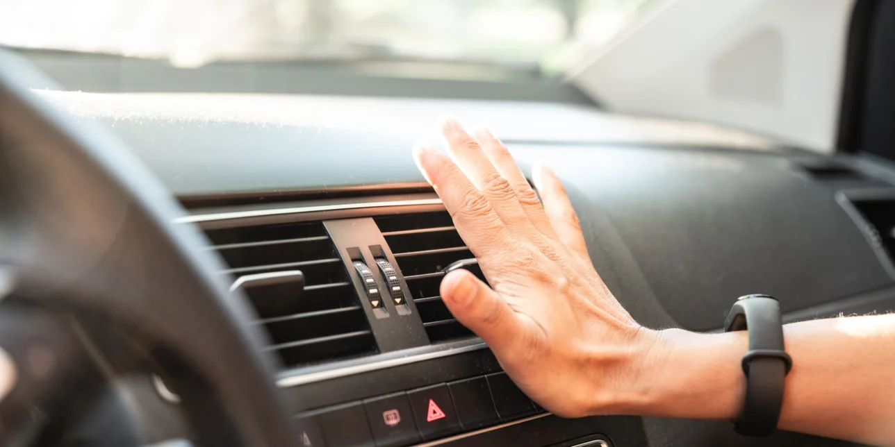Closeup of hand checking the air conditioner in the car.