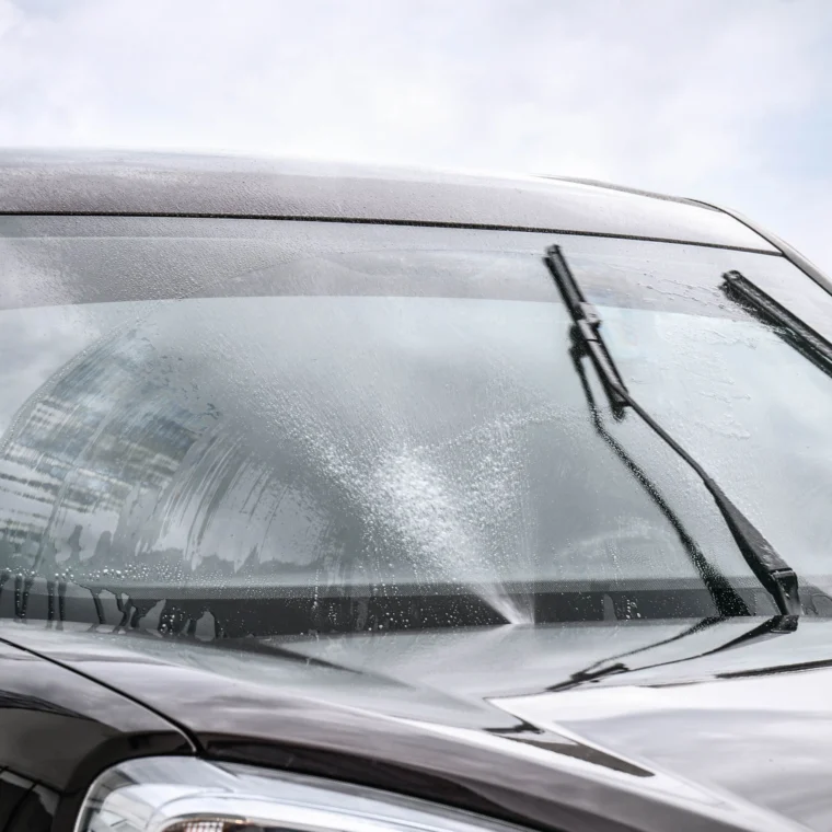 A vehicle's windshield wipers clearing of moisture on its windshield.
