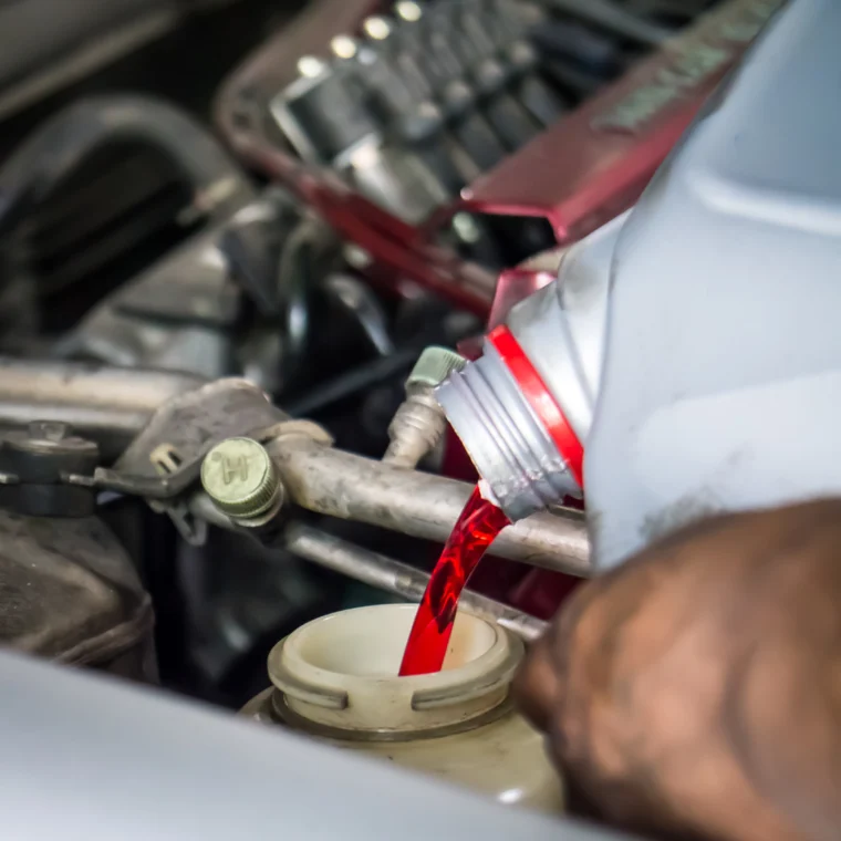 Hand pouring transmission fluid into a reservoir.