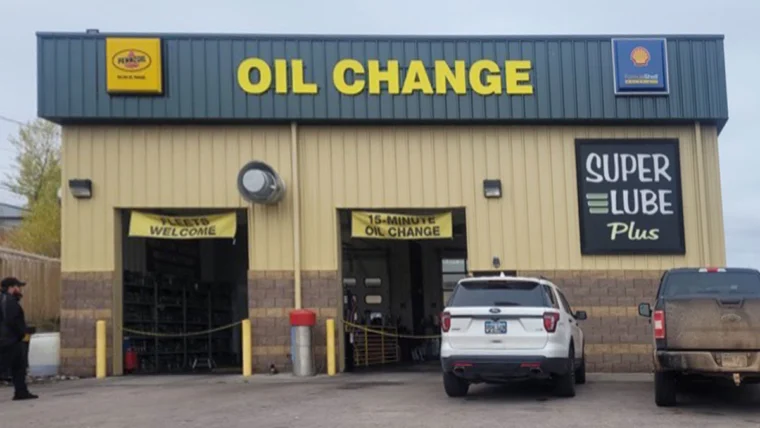 Exterior of Grease Monkey oil change center before renovation, showing older signage and faded building colors.