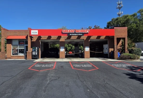 Renovated exterior of Grease Monkey oil change center with updated signage, fresh paint, and modern branding.