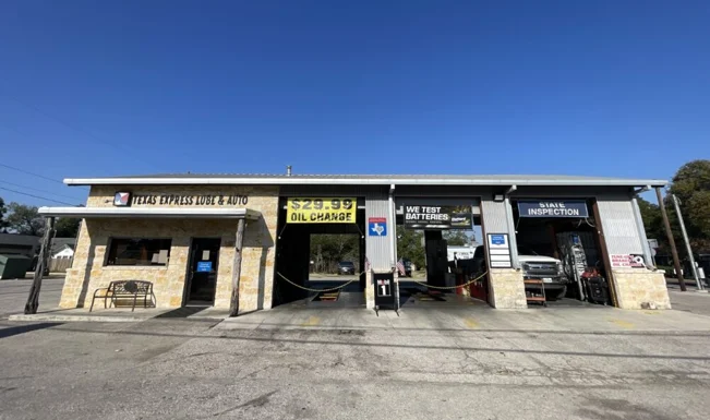 Exterior of Grease Monkey oil change center before renovation, showing older signage and faded building colors.