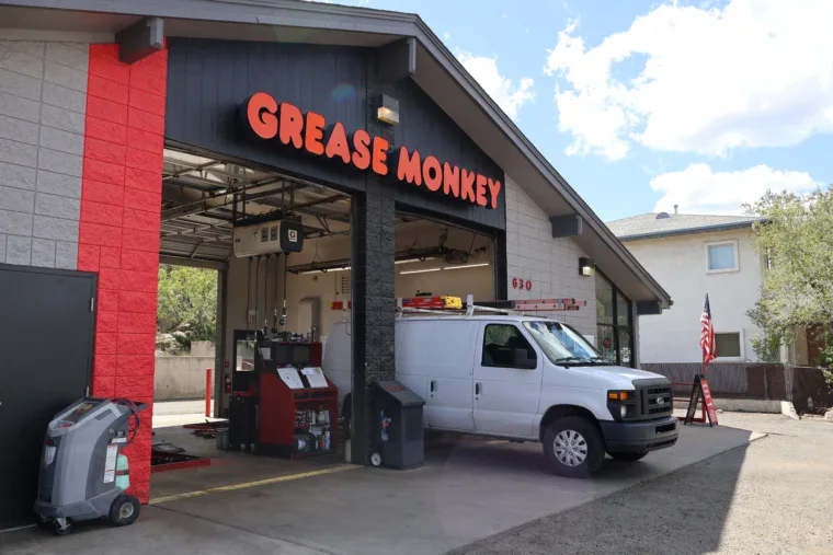 Fleet van pulling out of the Grease Monkey service bay after oil change and maintenance.