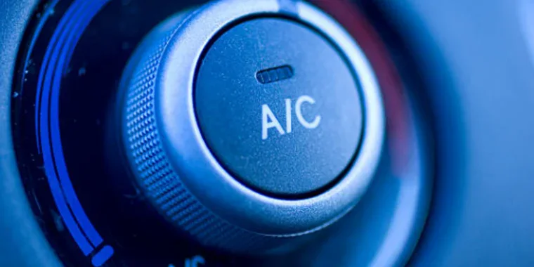 Close-up of a car air conditioning control knob showing the "A/C" label and surrounding temperature adjustment dial.