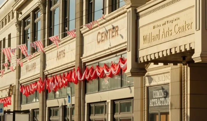 The exterior of the Willard Arts Center building in Idaho Falls, decorated with red and white bunting and a sign reading "Coming Attraction" in one window, catches the eye of every passing vehicle.