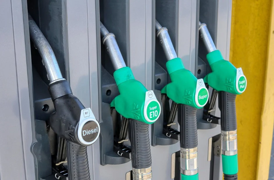 Four fuel pump nozzles at a Pocatello Idaho gas station labeled Diesel, Super E10, and Super, with green and black handles—perfect for your next car service stop.