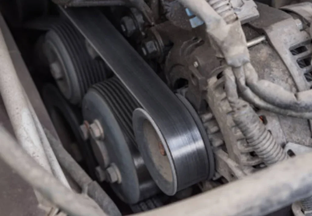 Close-up view of a car engine in Idaho Falls, showing the serpentine belt running around several pulleys and mechanical components—essential for vehicle air conditioning and many other reasons.