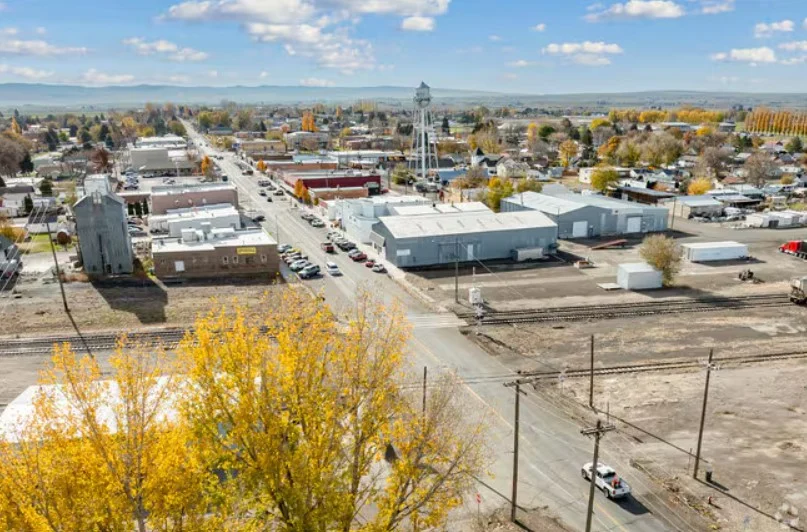 Aerial view of Kimberly, Idaho in Magic Valley with a water tower, main street, railroad tracks, and autumn trees under a partly cloudy sky—perfect for spotting local Vehicle Air Conditioning Service shops.