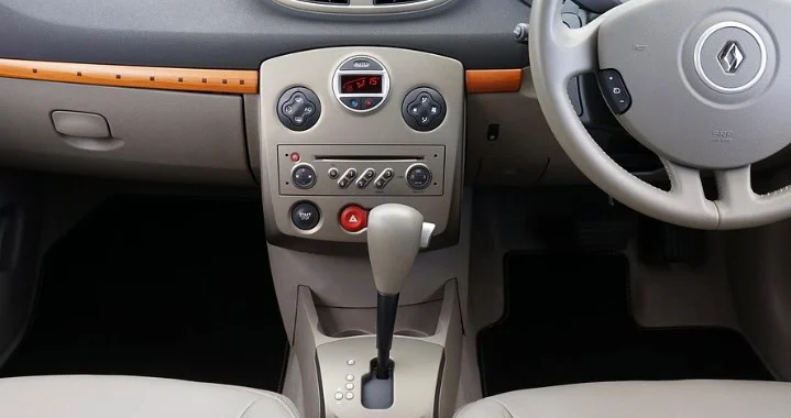 Beige car interior showing dashboard, automatic transmission gear shift, climate controls, and part of the steering wheel with Renault logo—ideal for your INL commute or daily drives around Idaho Falls.