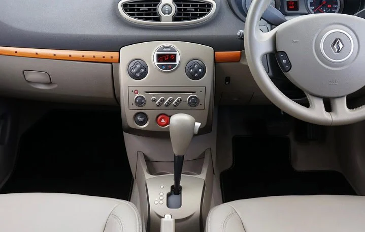 Beige car interior showing dashboard, automatic transmission gear shift, climate controls, and part of the steering wheel with Renault logo—ideal for your INL commute or daily drives around Idaho Falls.