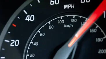 Close-up of a car speedometer showing a speed reading around 70 miles per hour, with speed markings in both MPH and km/h, captured while driving along the Business Loop near 2nd East Transmission in Rexburg.