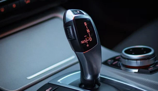 Close-up of a modern automatic car gear shifter, showing Park, Reverse, Neutral, and Drive options with illuminated letters—a sleek transmission system perfect for navigating the roads of Littleton.