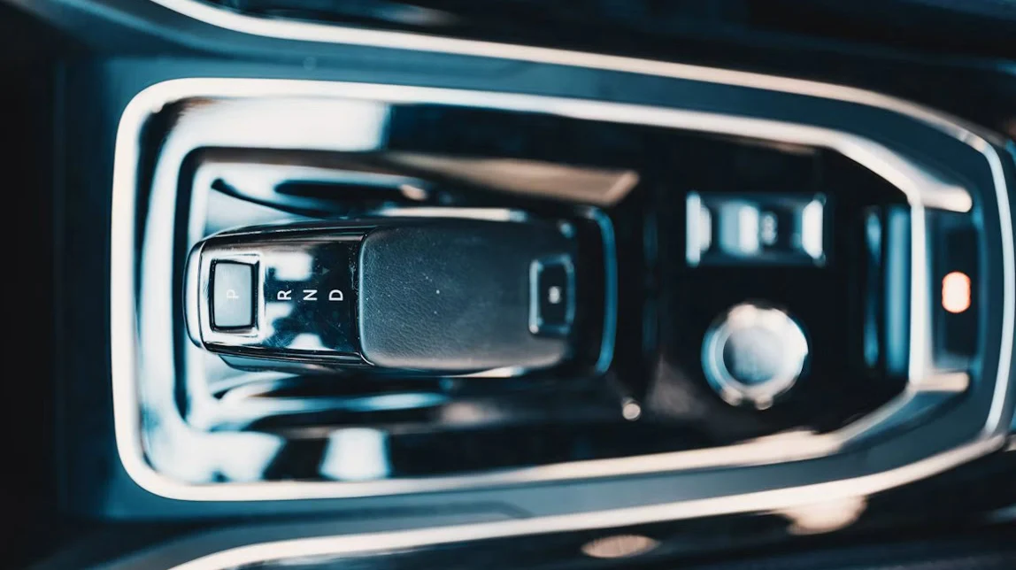Close-up of a car’s automatic gear shift with positions P, R, N, and D labeled—perfect for drivers navigating Rexburg or heading down the Business Loop. Surrounding controls and a silver knob from this 2nd East Transmission setup are partially visible.