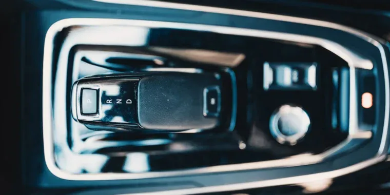 Close-up of a car’s automatic gear shift with positions P, R, N, and D labeled—perfect for drivers navigating Rexburg or heading down the Business Loop. Surrounding controls and a silver knob from this 2nd East Transmission setup are partially visible.