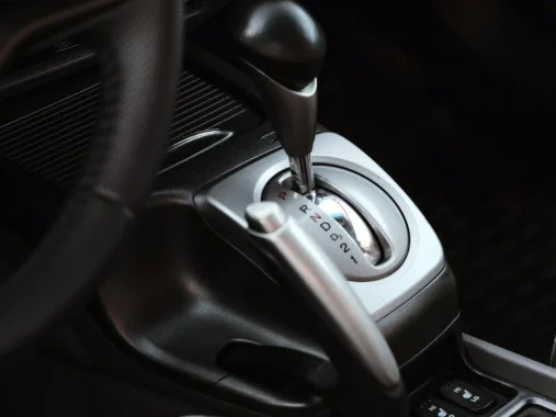Close-up of a car’s automatic transmission gear shift lever with positions labeled P, R, N, D, and L, located on the center console next to the driver’s seat—a common sight for drivers navigating the Yellowstone Highway Corridor near Rexburg.