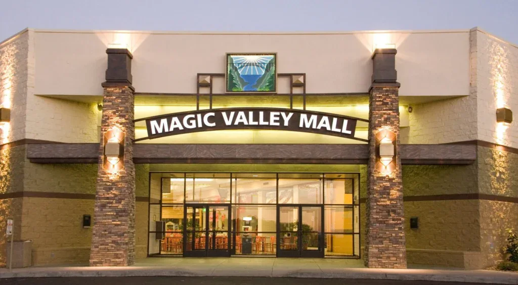 The main entrance of Magic Valley Mall in Twin Falls, featuring stone pillars, glass doors, and a sign with the mall’s name above the entrance, welcomes visitors seeking shopping, dining, and even convenient vehicle service like brake system checks nearby.