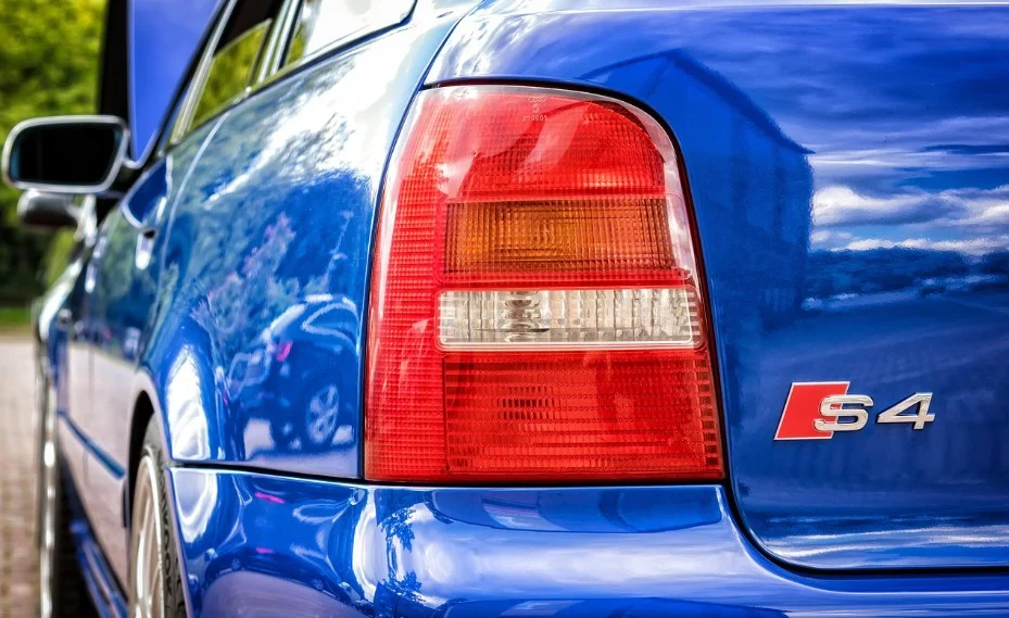 Close-up of the rear left side of a blue Audi S4 car in Elizabeth, Colorado, showing the tail light and S4 badge, with reflections visible on the car’s surface—a perfect showcase for expert brake inspection and brake service.
