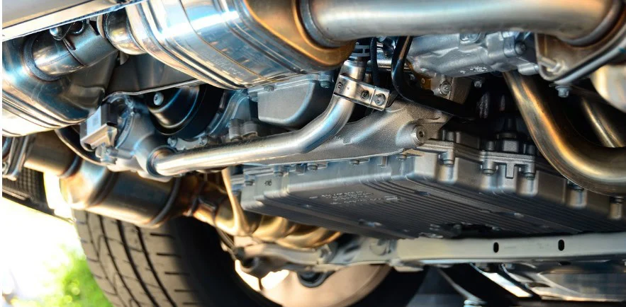 Close-up view of the underside of a car showing parts of the exhaust system, transmission, and rear wheel—similar to what you might inspect when diagnosing ranch transmission problems in Elizabeth Colorado ranch vehicles.