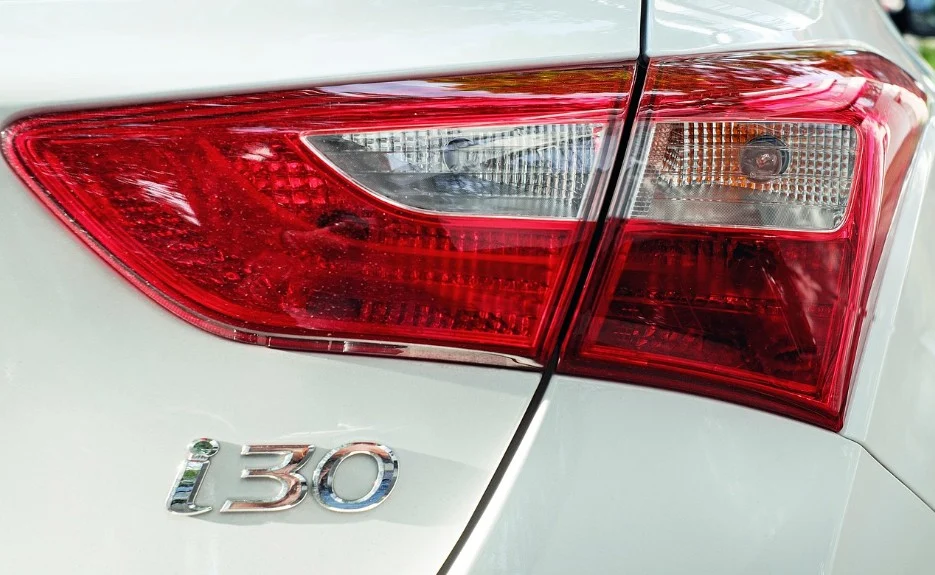 Close-up of the rear taillight and the “i30” badge on a white car.