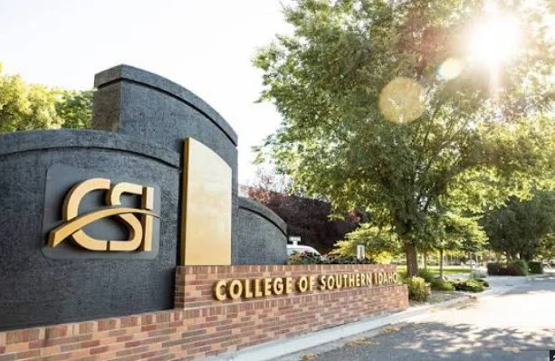 Sign for College of Southern Idaho with logo, surrounded by trees, on a sunny day in Twin Falls, Idaho.