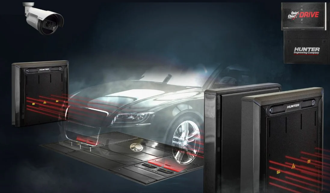 A car drives over a scanning platform surrounded by security sensors, laser beams, and a surveillance camera, illustrating a Quick Check vehicle inspection and alignment system in Idaho Falls.