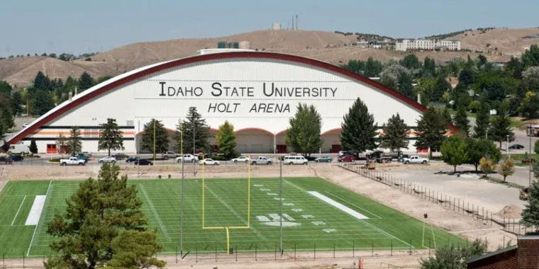 View of Holt Arena at Idaho State University with a green football field in the foreground and hills in the background—a picturesque scene that highlights some of the unique landscapes you might encounter while traveling through Idaho for car maintenance or picking up essential parts like a cabin air filter, whether you’re coming from Rexburg, Idaho or beyond.