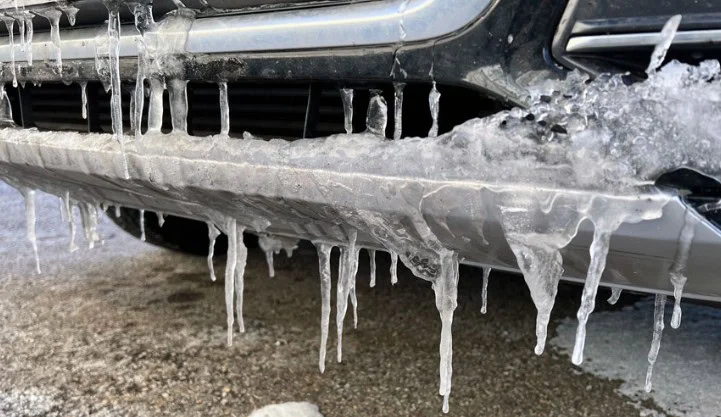 Icicles hanging from the bumper and grille of a vehicle, with ice buildup visible on the front in a cold Rexburg Idaho outdoor setting—a clear reminder that proper car maintenance, like checking your cabin air filter, is essential for safe winter driving.