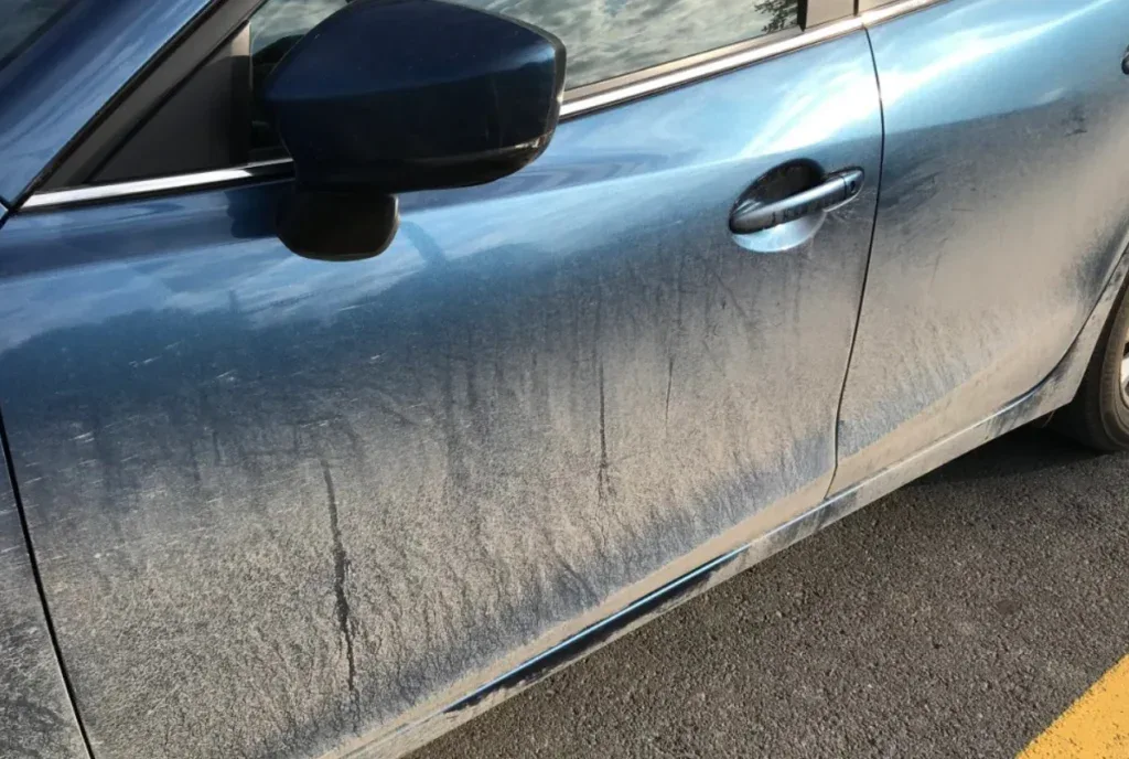 Side view of a dusty blue farm vehicle door.