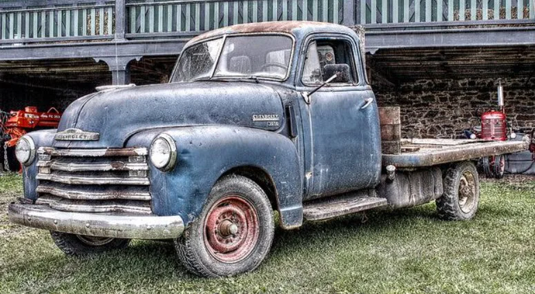 A vintage blue Chevrolet flatbed truck parked on grass in Kimberly, Idaho.