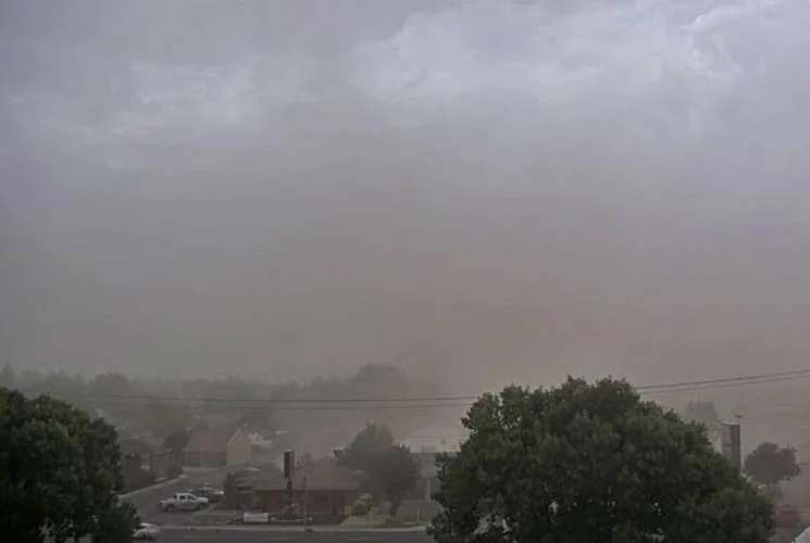 A suburban area in Twin Falls obscured by a thick, hazy dust storm, highlighting the importance of regular engine air filter maintenance.