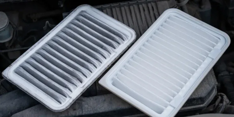A dirty, used engine air filter from Elizabeth Ranch next to a clean, new replacement filter.