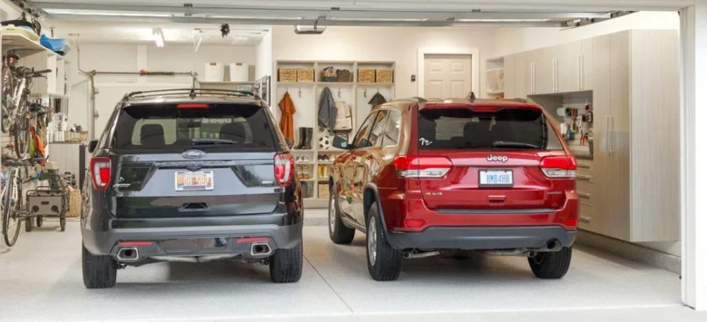 A black Ford Explorer and a red Jeep Grand Cherokee parked in a Twin Falls garage during car maintenance.